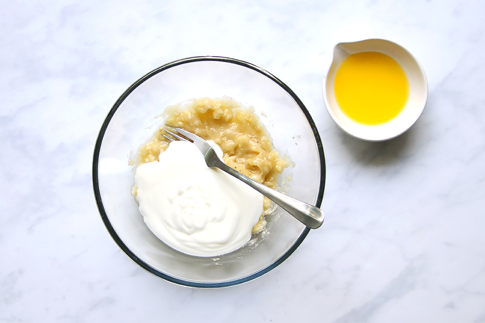 Mashed bananas and yogurt in bowl