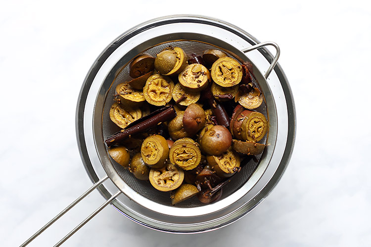 Strained cut green walnuts for spiced walnut liqueur recipe