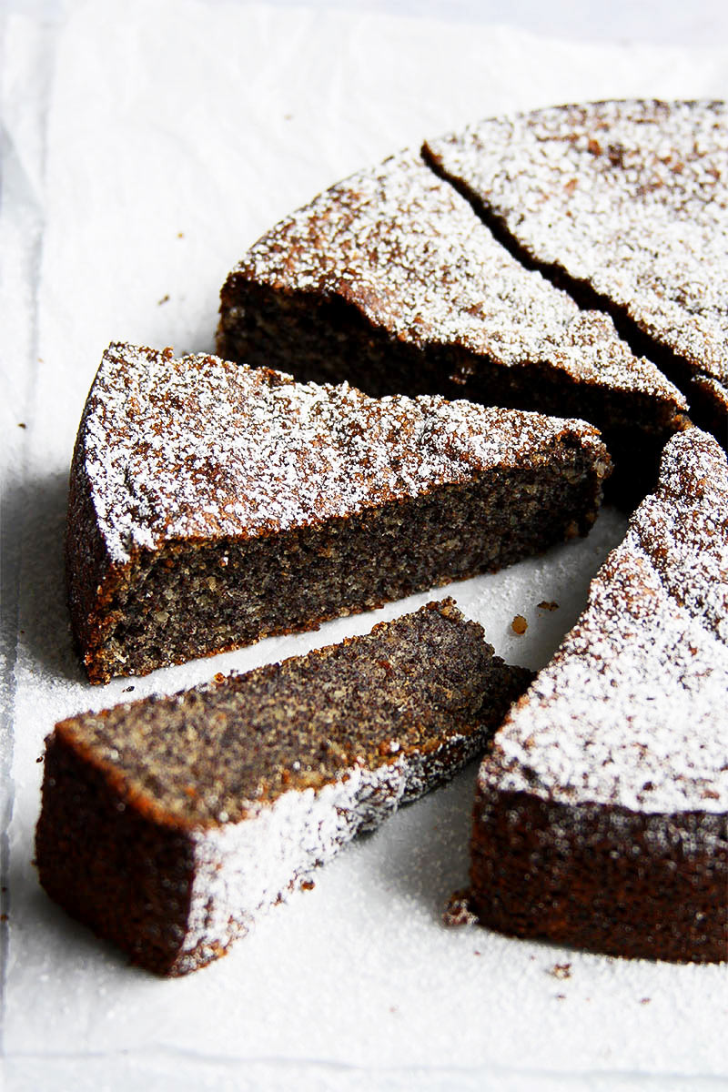 Dark, sliced poppy seed cake dusted with powdered sugar