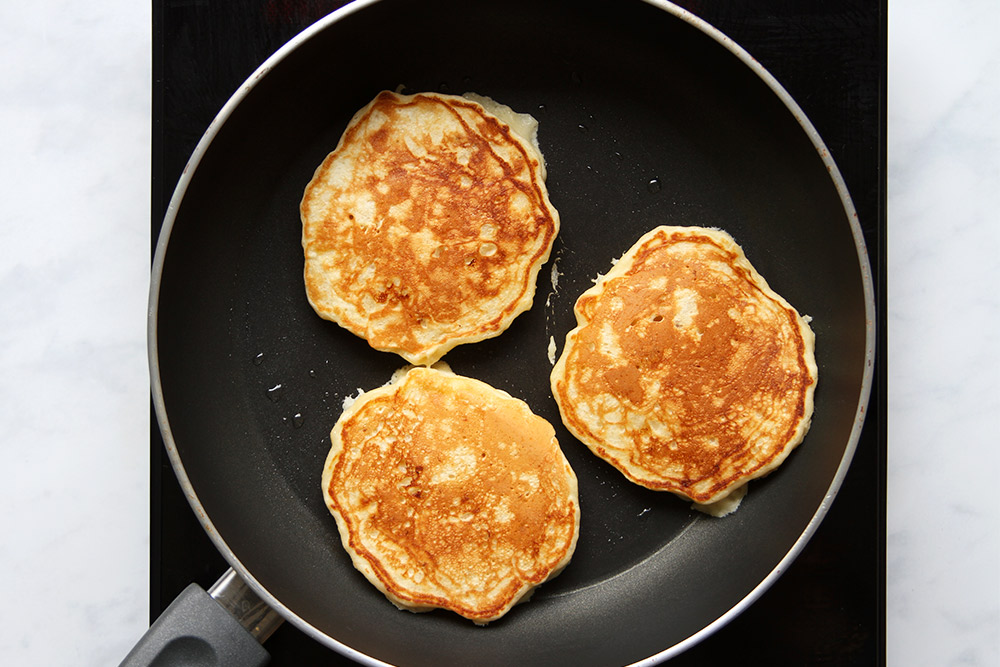 Flipped banana pancakes in pan