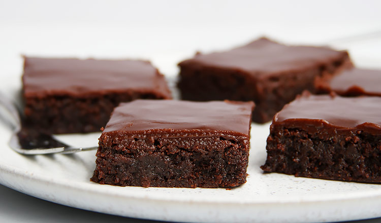 Poppy seed brownies with ganache on plate