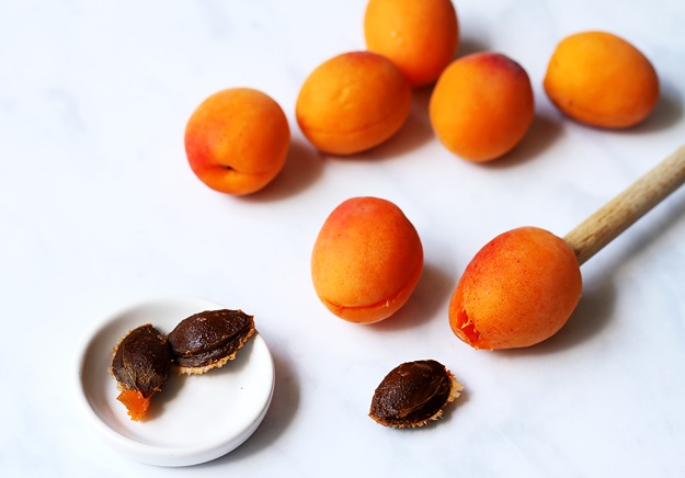 Pitting apricots with back of cooking spoon for apricot dumplings