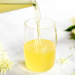 Pouring elderflower syrup in glass